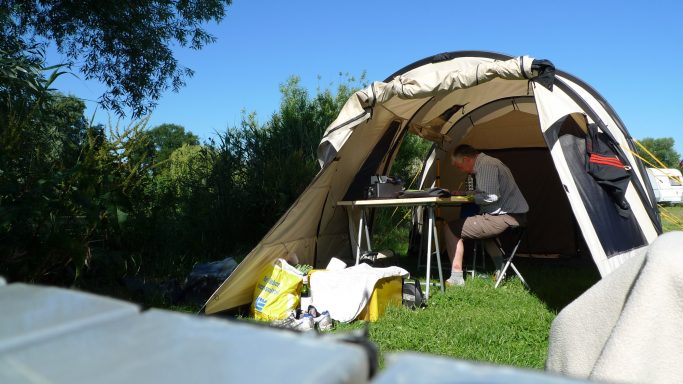 Bei warmen Wetter kein Problem. Zelt mit Tisch und Personen in